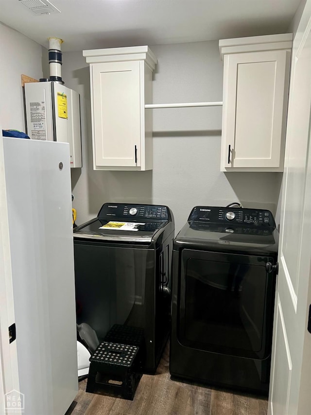 5204 Bridger Park Ct, Jonesboro, AR 72405 - laundry room with washing machine and dryer, dark wood-style floors, tankless water heater, and cabinet space