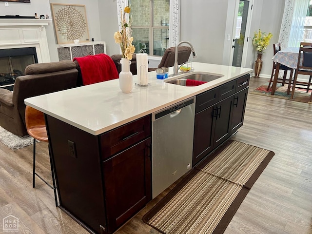 5204 Bridger Park Ct, Jonesboro, AR 72405 - kitchen with stainless steel dishwasher, light wood-style flooring, light countertops, and a kitchen island with sink