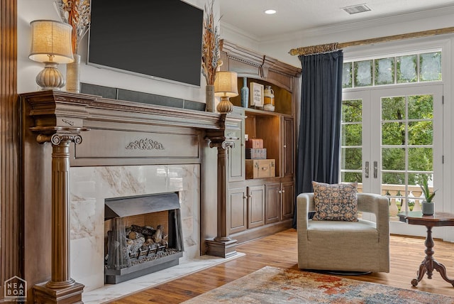 3500 Big Creek Cv, Jonesboro, AR 72404 - living area featuring ornamental molding, plenty of natural light, light wood-style flooring, french doors, and a premium fireplace