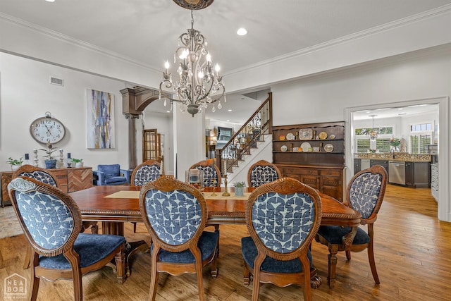 3500 Big Creek Cv, Jonesboro, AR 72404 - dining area featuring a chandelier, crown molding, wood finished floors, stairs, and recessed lighting