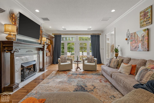 3500 Big Creek Cv, Jonesboro, AR 72404 - living area with a high end fireplace, ornamental molding, a textured ceiling, wood finished floors, and recessed lighting