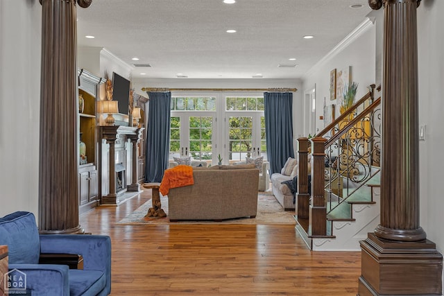 3500 Big Creek Cv, Jonesboro, AR 72404 - living room with decorative columns, ornamental molding, a textured ceiling, stairs, and wood finished floors