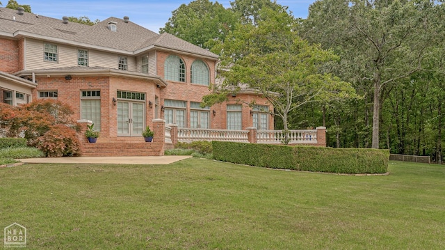 3500 Big Creek Cv, Jonesboro, AR 72404 - view of front of property featuring french doors, brick siding, a front lawn, a wooden deck, and a shingled roof