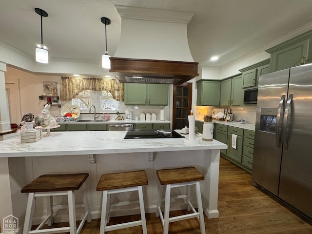 kitchen with tasteful backsplash, a sink, appliances with stainless steel finishes, green cabinets, and custom range hood