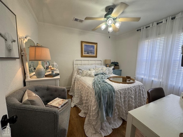 bedroom featuring crown molding, wood finished floors, a ceiling fan, and visible vents