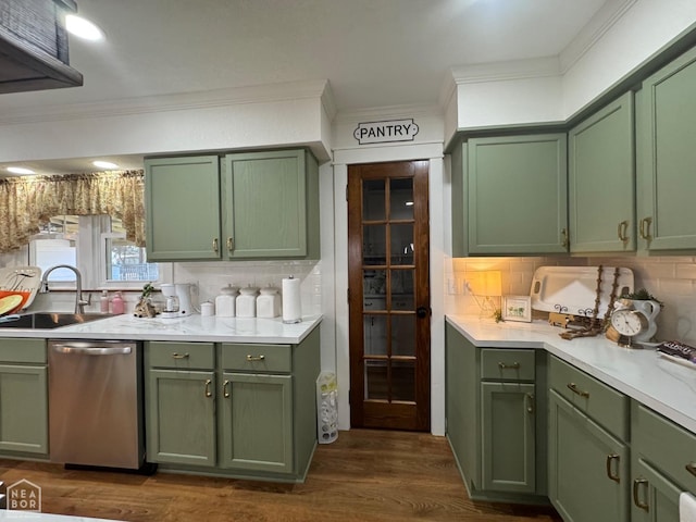 kitchen with green cabinets, dishwasher, a sink, and ornamental molding