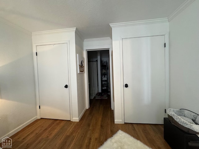 bedroom with crown molding, baseboards, wood finished floors, and a textured ceiling