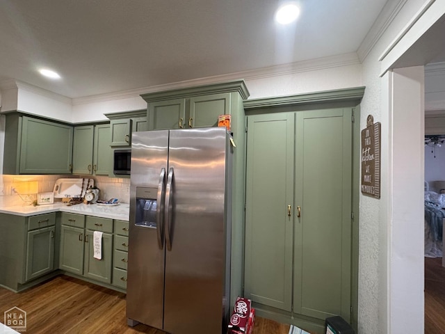 kitchen featuring green cabinets, appliances with stainless steel finishes, crown molding, and dark wood finished floors