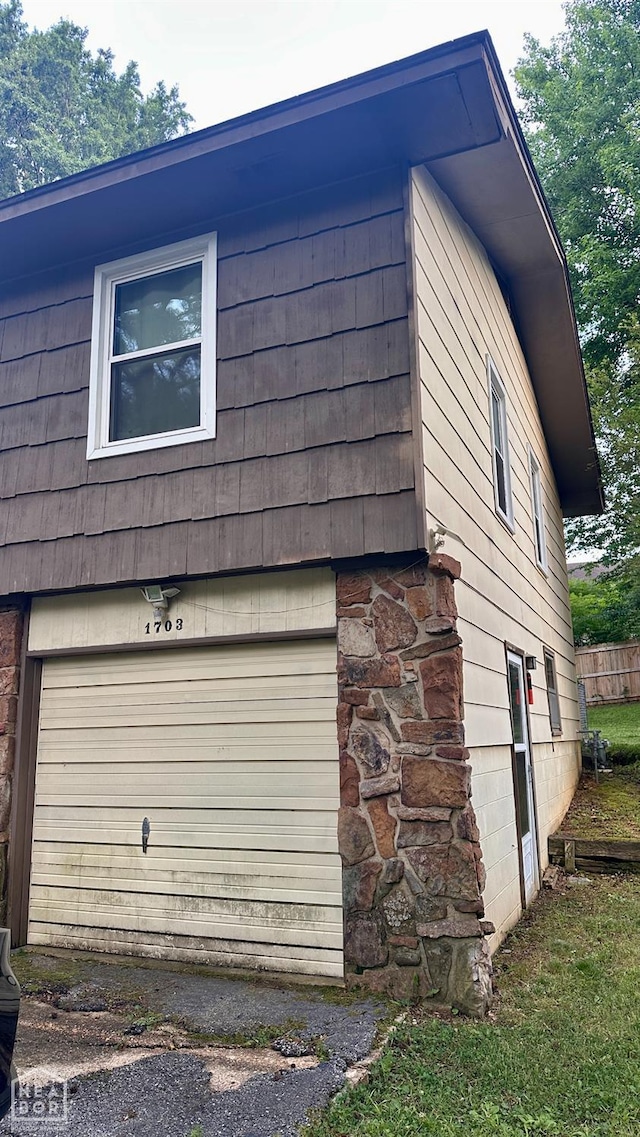 1703 W Oak Ave, Jonesboro, AR 72401 - view of home's exterior with an attached garage and stone siding