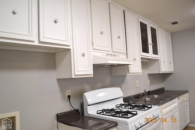 kitchen with white cabinets, under cabinet range hood, white appliances, and glass insert cabinets