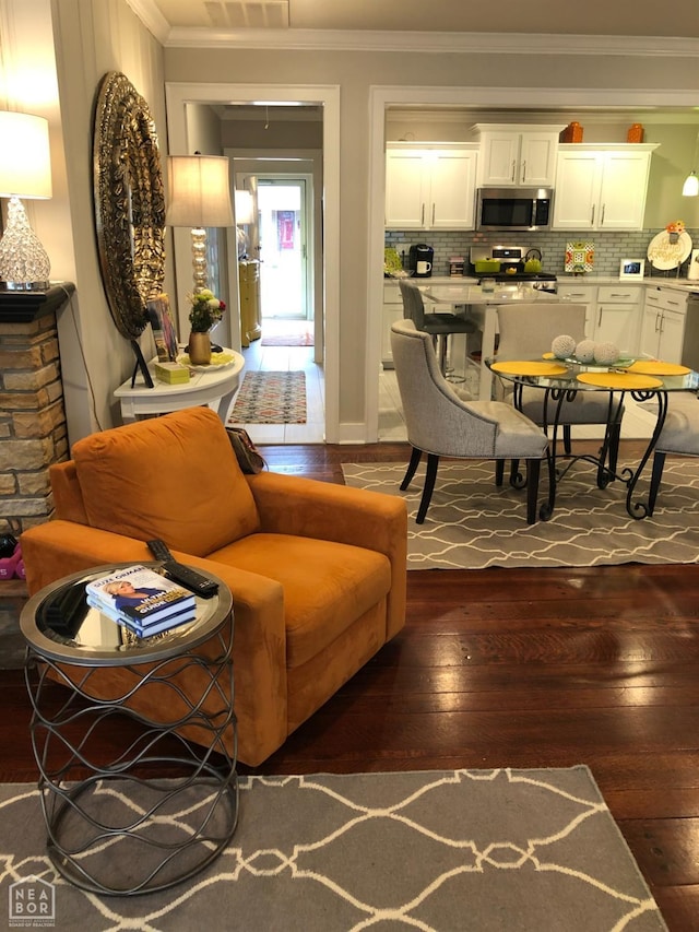 living area featuring visible vents, dark wood-style flooring, and ornamental molding