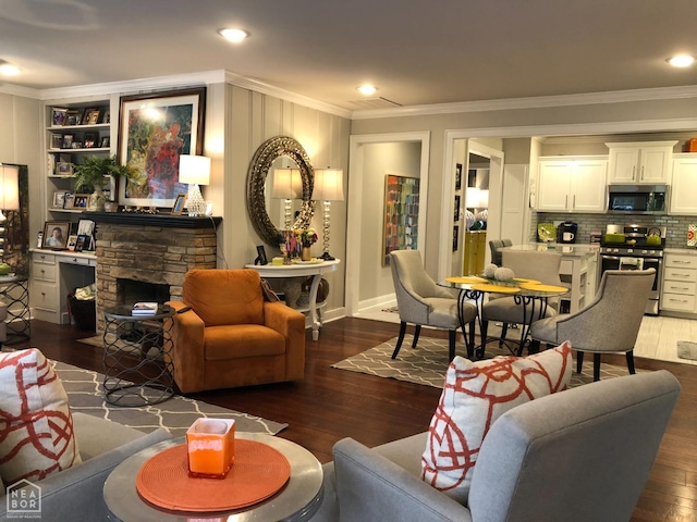 living room with ornamental molding, a stone fireplace, recessed lighting, and dark wood finished floors