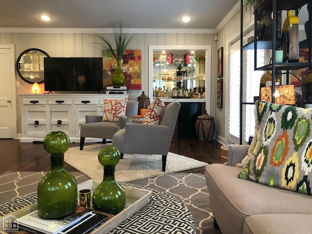 living room featuring ornamental molding, a bar, and dark wood-style floors