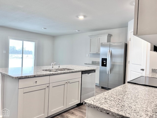 112 Terry Dr, Brookland, AR 72417 - kitchen with appliances with stainless steel finishes, light wood-type flooring, a sink, a kitchen island with sink, and light stone countertops