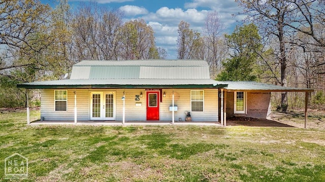 view of front of property with french doors, a carport, covered porch, metal roof, and a front yard