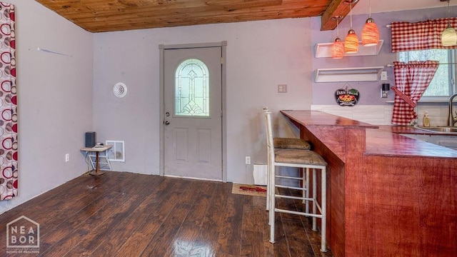 foyer with wood finished floors, visible vents, and wooden ceiling