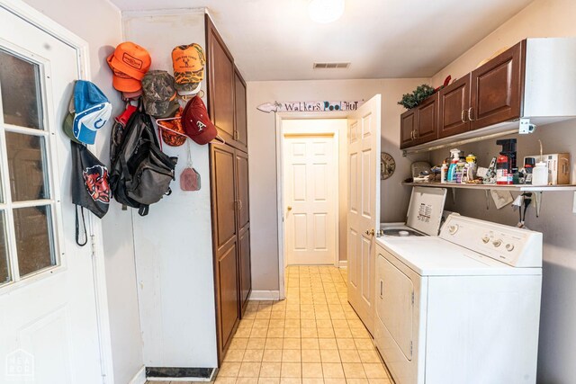 304 E Ridge Dr, West Helena, AR 72390 - laundry room featuring cabinet space, light tile patterned floors, washing machine and clothes dryer, and baseboards