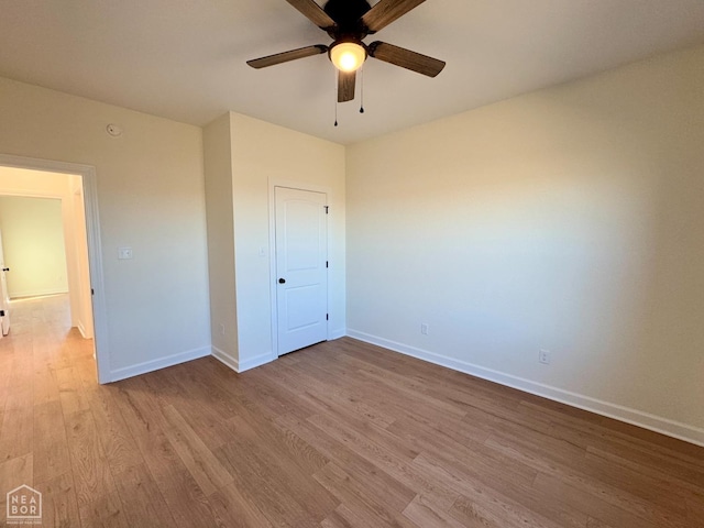 unfurnished bedroom featuring a closet, baseboards, a ceiling fan, and wood finished floors
