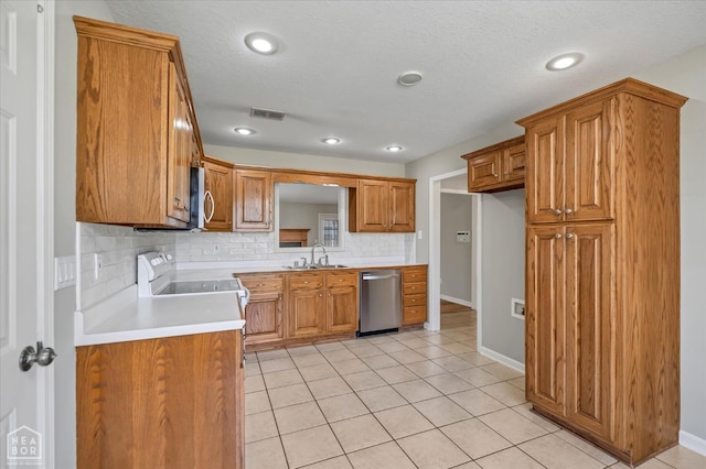 301 Natchez Dr, Jonesboro, AR 72404 - kitchen featuring visible vents, a sink, brown cabinetry, stainless steel appliances, and backsplash