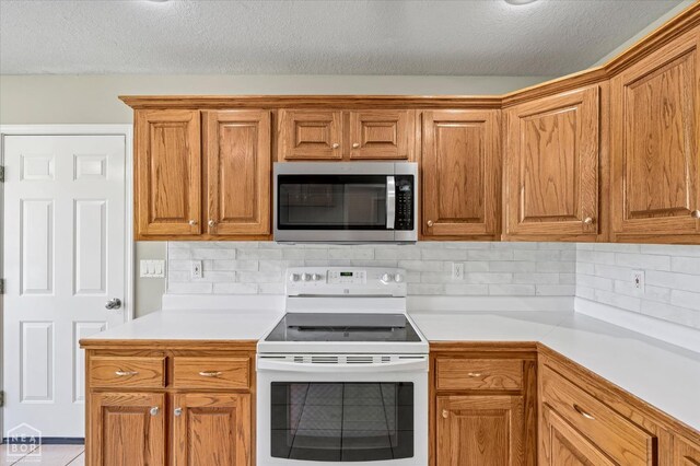 301 Natchez Dr, Jonesboro, AR 72404 - kitchen featuring tasteful backsplash, light countertops, stainless steel microwave, and electric stove
