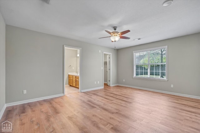 301 Natchez Dr, Jonesboro, AR 72404 - unfurnished bedroom featuring baseboards, ensuite bathroom, a walk in closet, light wood-style floors, and visible vents