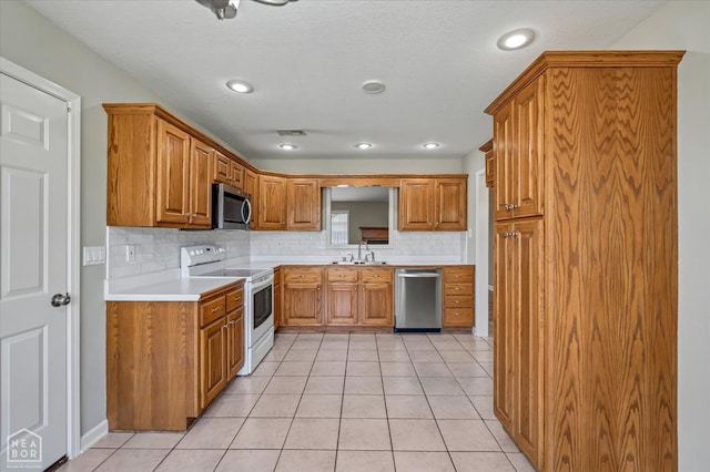 301 Natchez Dr, Jonesboro, AR 72404 - kitchen with light tile patterned floors, visible vents, a sink, stainless steel appliances, and brown cabinets