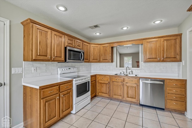 301 Natchez Dr, Jonesboro, AR 72404 - kitchen featuring visible vents, a sink, light countertops, appliances with stainless steel finishes, and brown cabinets