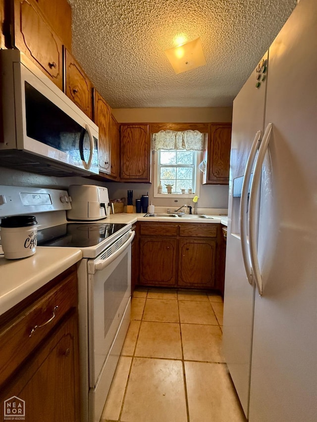 500 Oak St, Trumann, AR 72472 - kitchen with white appliances, brown cabinetry, a textured ceiling, light countertops, and light tile patterned floors