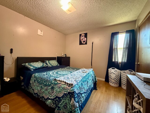 500 Oak St, Trumann, AR 72472 - bedroom with wood finished floors and a textured ceiling