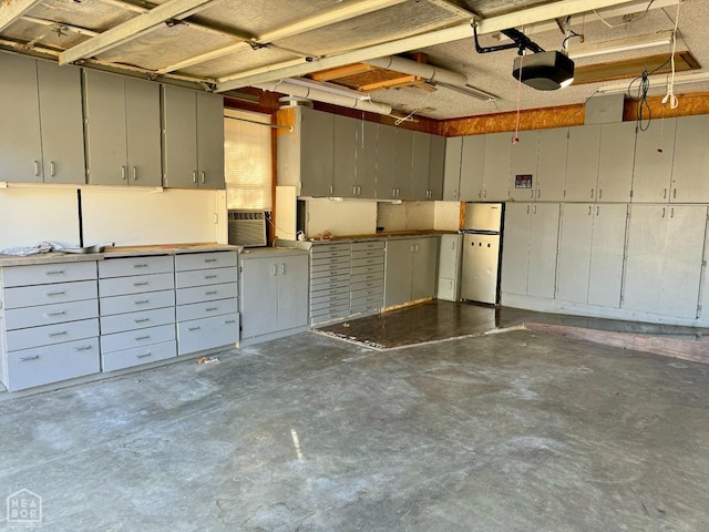 3426 Aggie Rd, Jonesboro, AR 72405 - garage with a garage door opener and freestanding refrigerator