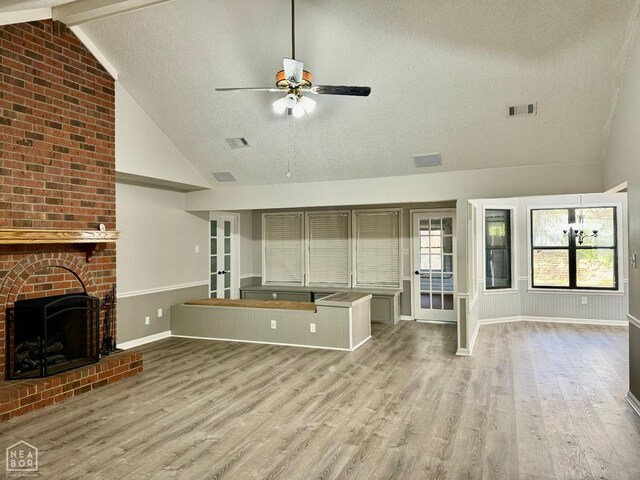 3426 Aggie Rd, Jonesboro, AR 72405 - unfurnished living room featuring high vaulted ceiling, a ceiling fan, a textured ceiling, light wood-style floors, and a brick fireplace