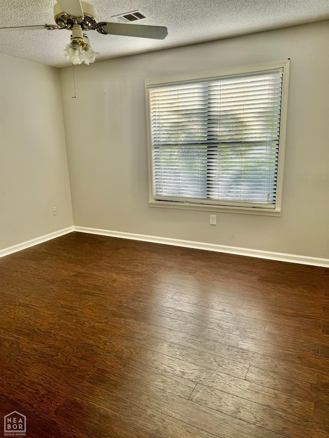 3426 Aggie Rd, Jonesboro, AR 72405 - unfurnished room with a textured ceiling, dark wood-style floors, ceiling fan, and baseboards