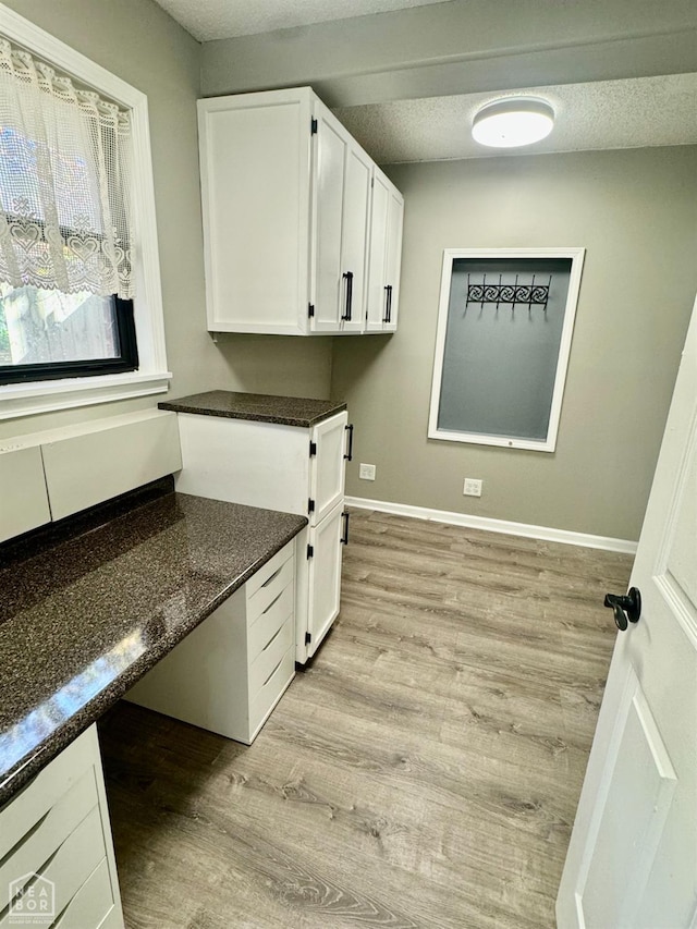 3426 Aggie Rd, Jonesboro, AR 72405 - laundry room featuring light wood-type flooring, a textured ceiling, and baseboards