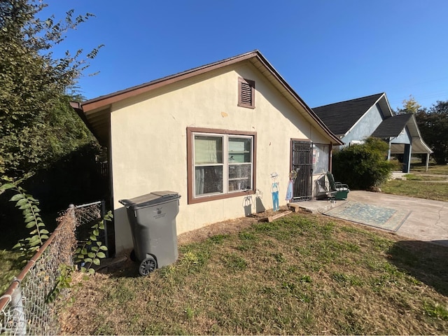 1003 W Emerson St W, Paragould, AR 72450 - rear view of property with a yard, a patio area, and stucco siding