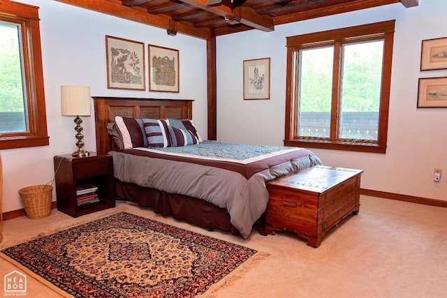  - bedroom featuring wood ceiling, light colored carpet, multiple windows, and beam ceiling