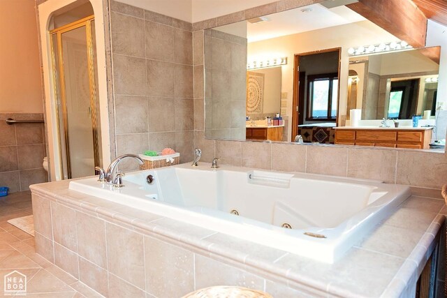  - full bathroom featuring a whirlpool tub, vanity, tile patterned flooring, toilet, and tile walls