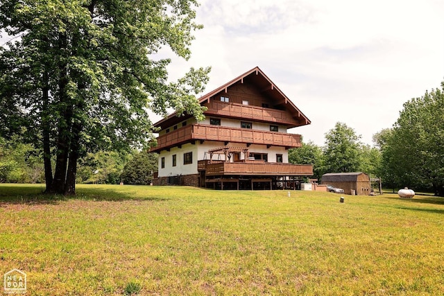  - back of property featuring a storage shed, an outbuilding, a lawn, and a balcony