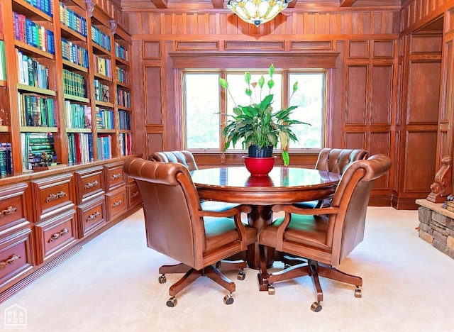  - dining space featuring wooden walls, a decorative wall, and light carpet