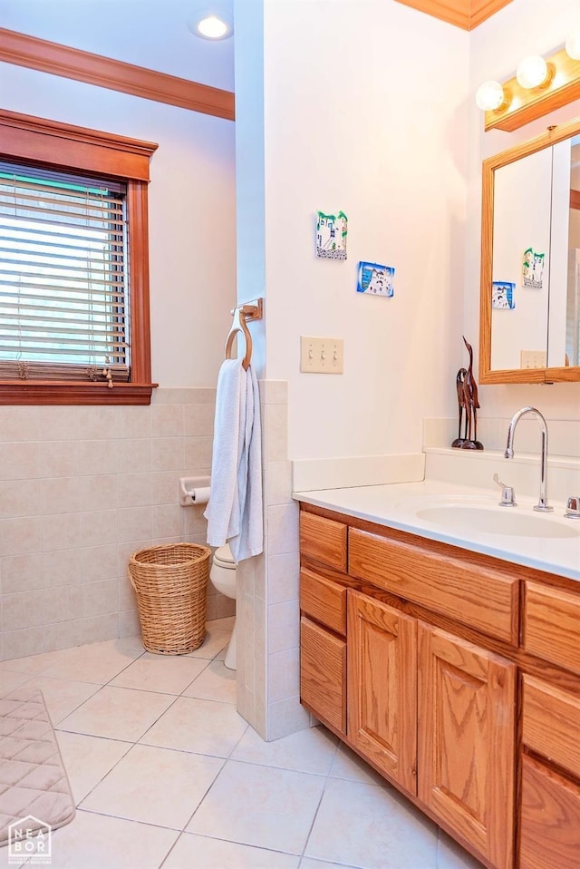  - bathroom featuring toilet, tile walls, a wainscoted wall, vanity, and tile patterned floors