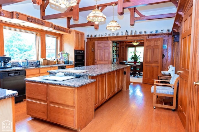  - kitchen with a healthy amount of sunlight, beam ceiling, black appliances, and a kitchen island