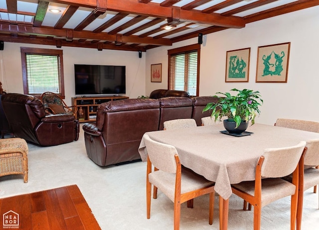  - dining space featuring light carpet, beamed ceiling, and ceiling fan