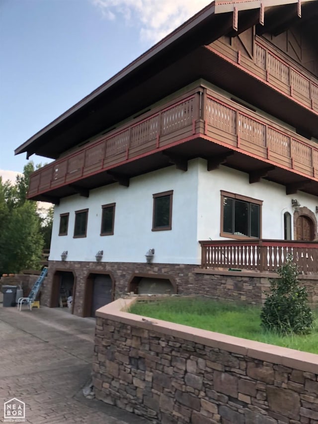  - view of building exterior featuring an attached garage and driveway