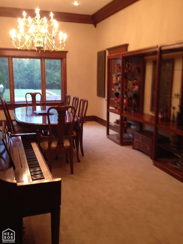  - dining area with ornamental molding, baseboards, carpet flooring, and an inviting chandelier