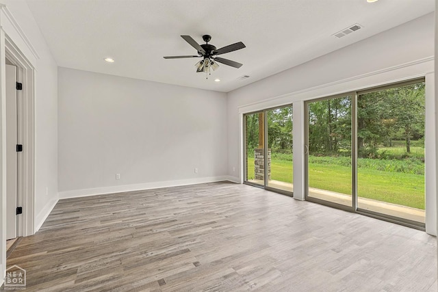 empty room featuring a ceiling fan, visible vents, recessed lighting, wood finished floors, and baseboards