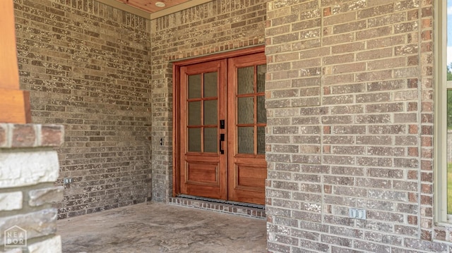 doorway to property featuring brick siding and french doors