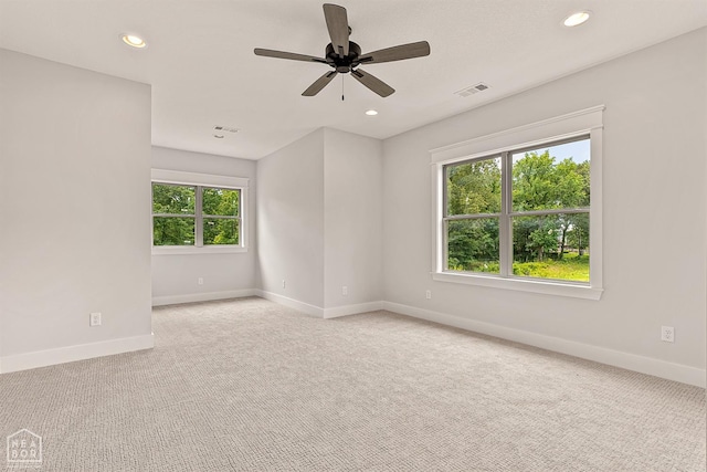 spare room featuring light carpet, baseboards, visible vents, and recessed lighting