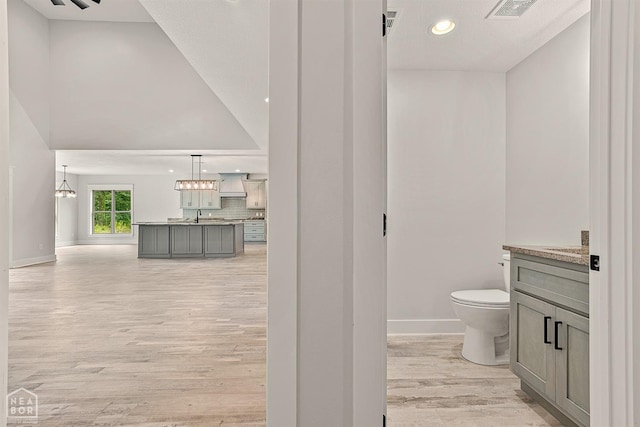 bathroom with backsplash, vanity, visible vents, and toilet