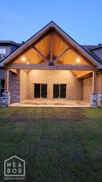 rear view of house featuring a patio area and a lawn