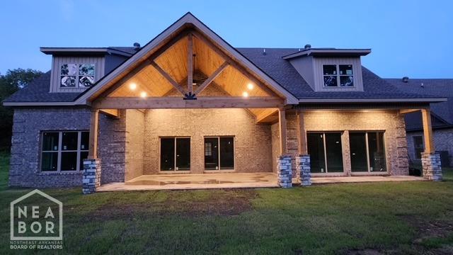 rear view of property with a yard, a patio area, and brick siding