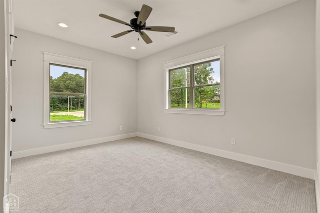 unfurnished room featuring a wealth of natural light, carpet, and baseboards